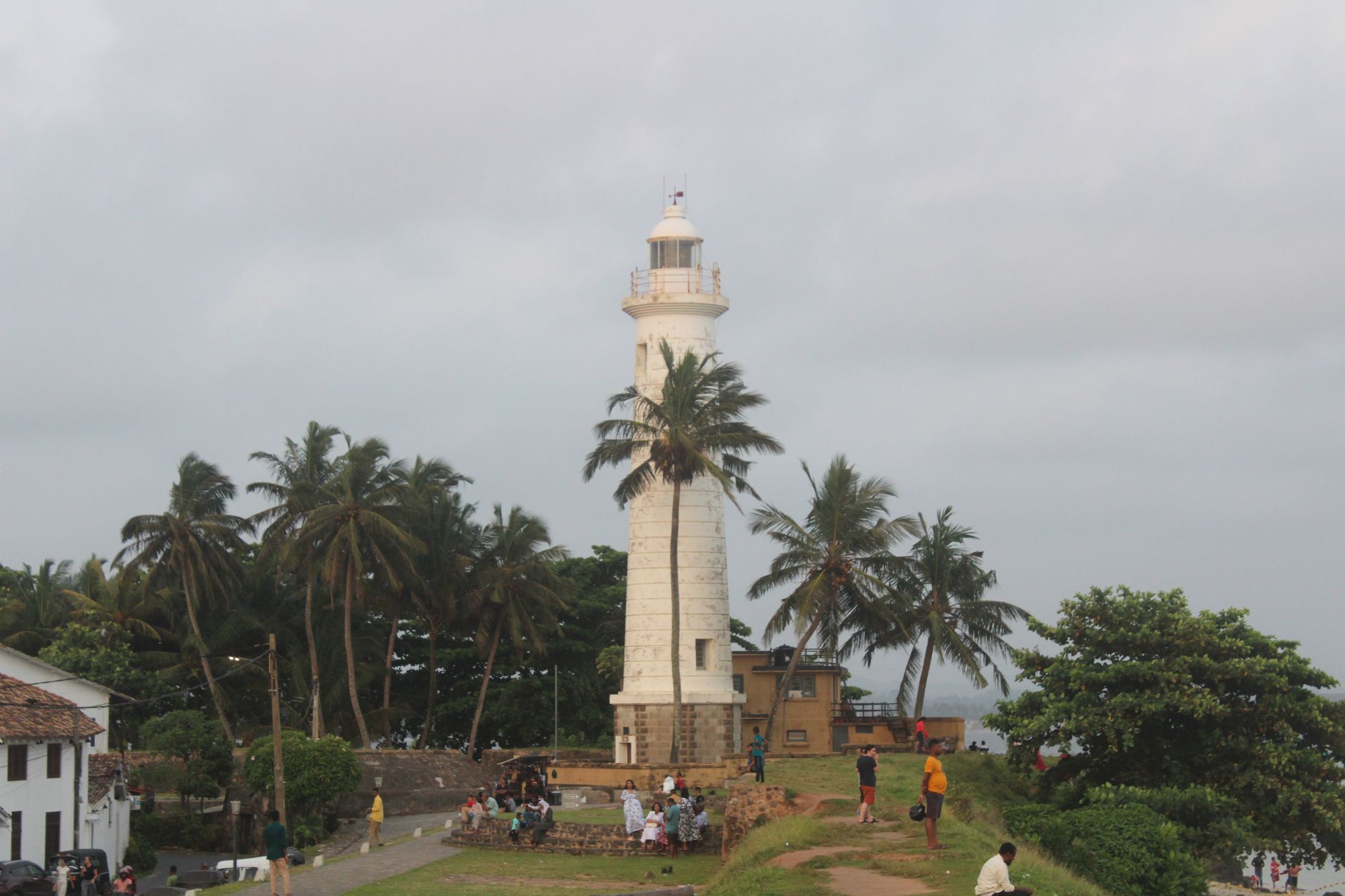 The Galle Fort Lighthouse in Sri Lanka, with locals and tourists gathered nearby to enjoy the view.