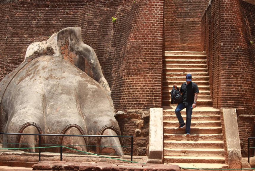 A man climbing down the steps of the Lion's gate in Sigiriya Rock, Sri Lanka.