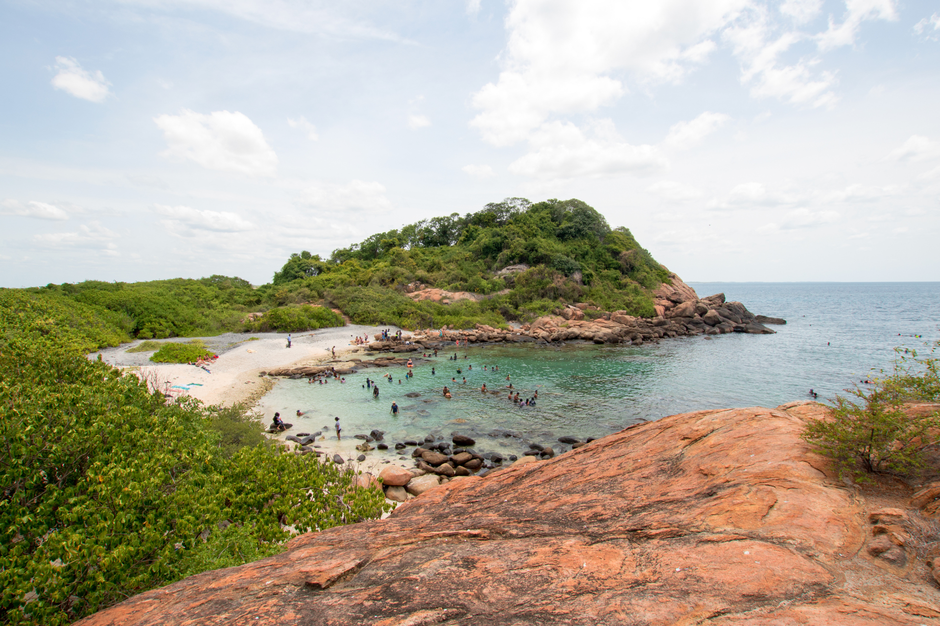 People bathing in the sea near Pigeon island in Trincomalee, Sri Lanka
