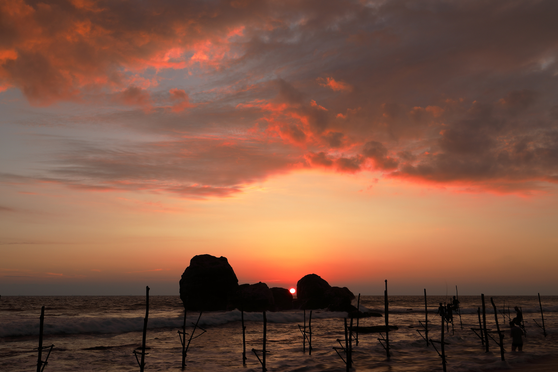 Sunset at Koggala Beach near Galle, with fishing stilts scattered across the beach