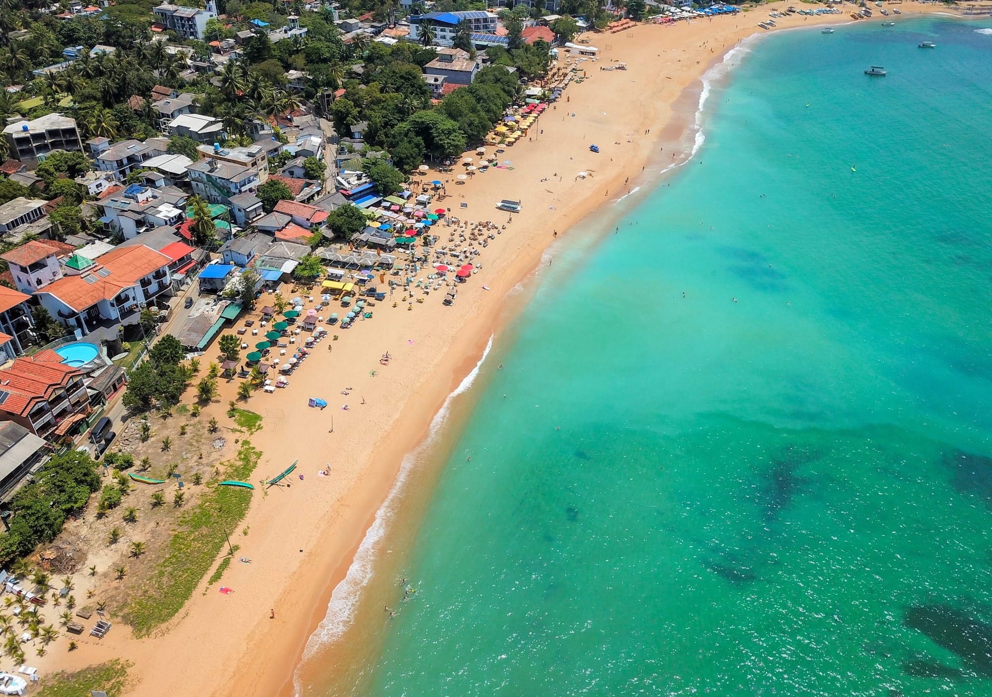 Unawatuna Beach near Galle, with its turquoise waters, hotels and beachgoers seen from above